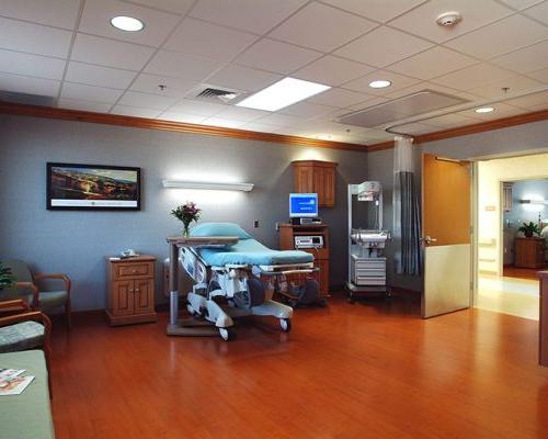 大医院卧室的内景照片. 木地板和冷灰色墙壁.